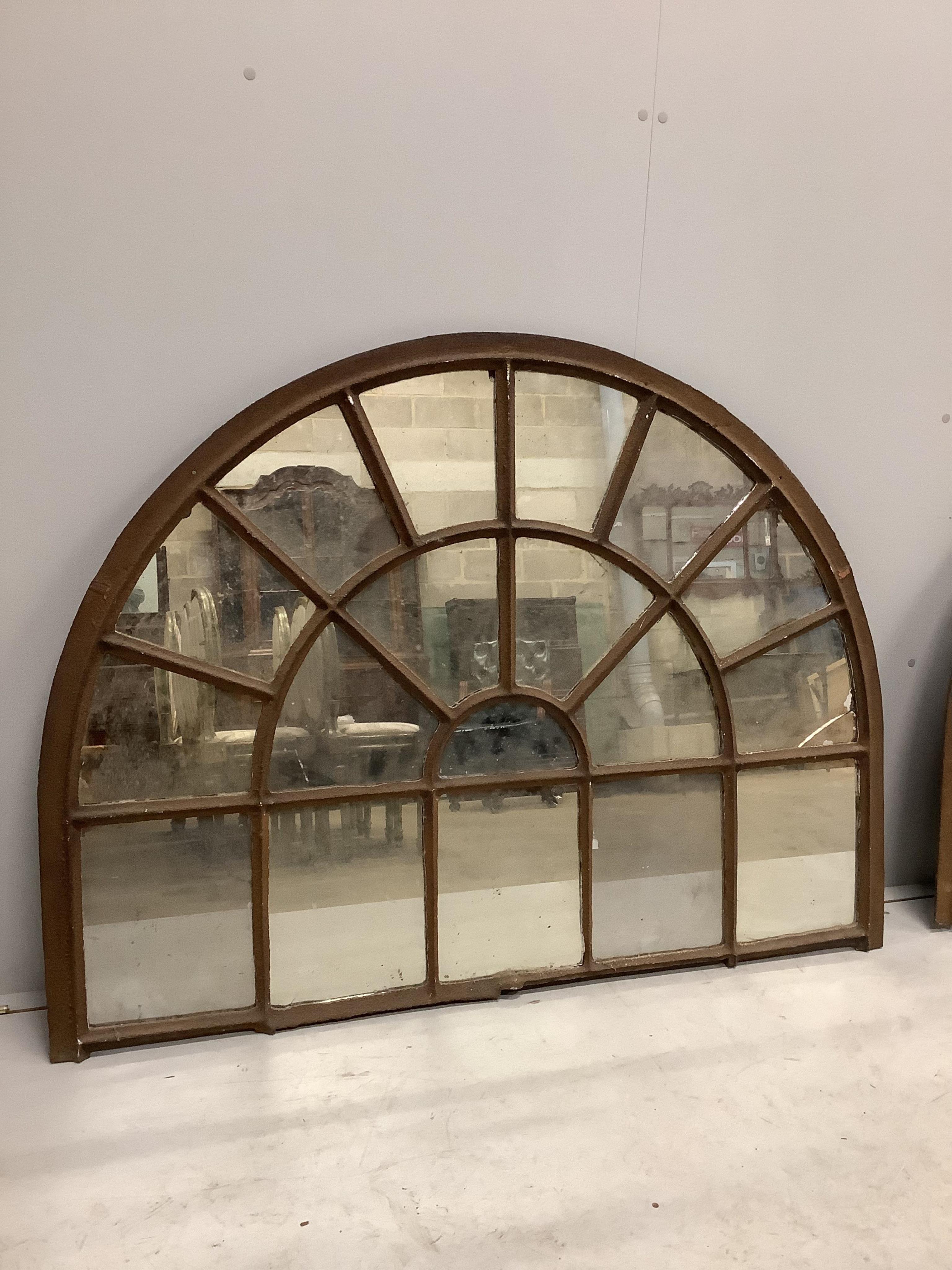 A pair of architectural cast iron window panel wall mirrors of domed form, width 136cm, height 102cm. Condition - fair, four panes cracked.